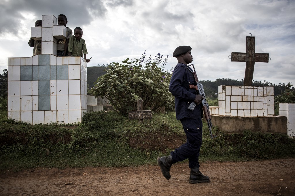BURYING EBOLA VICTIMS. A police officer escorts the coffins containing two victims of ebola as they enter a graveyard on May 16, 2019 in Butembo. Photo by John Wessels/AFP 