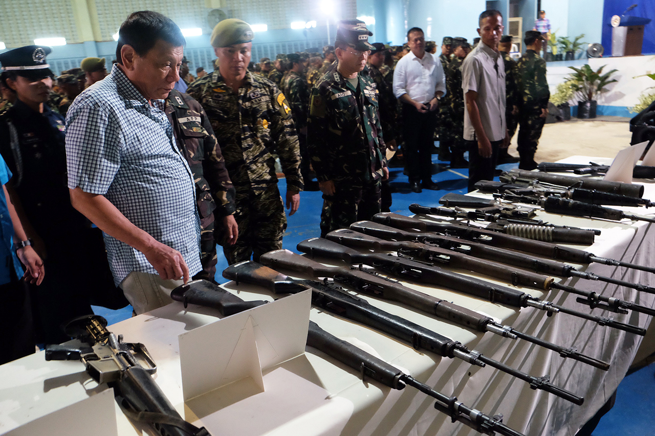 INSPECTION. President Duterte inspects the firearms recovered from the New People's Army (NPA) rebels during his visit at Camp Edilberto Evangelista in Patag, Cagayan de Oro City on August 9. Photo by Kiwi Bulaclac/PPD 