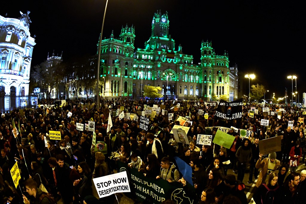 MARCHING FOR THE CLIMATE. Demonstrators walk past the city hall on Cibeles Square during a mass climate march to demand urgent action on the climate crisis from world leaders attending the COP25 summit, in Madrid, on December 6, 2019. Photo by Oscar Del Pozo/AFP 