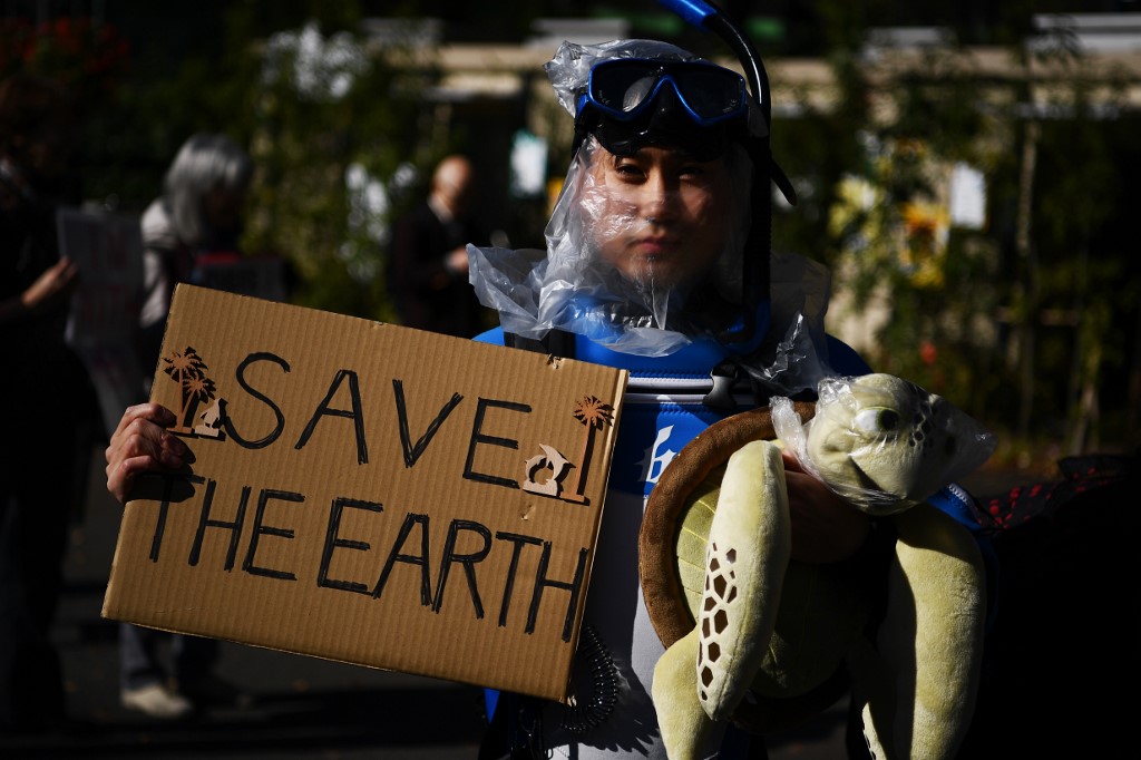 'SAVE THE EARTH.' A participants holds up a placard to call for action on climate change during a march in Tokyo on November 29, 2019. Photo by Charly Triballeu/AFP 