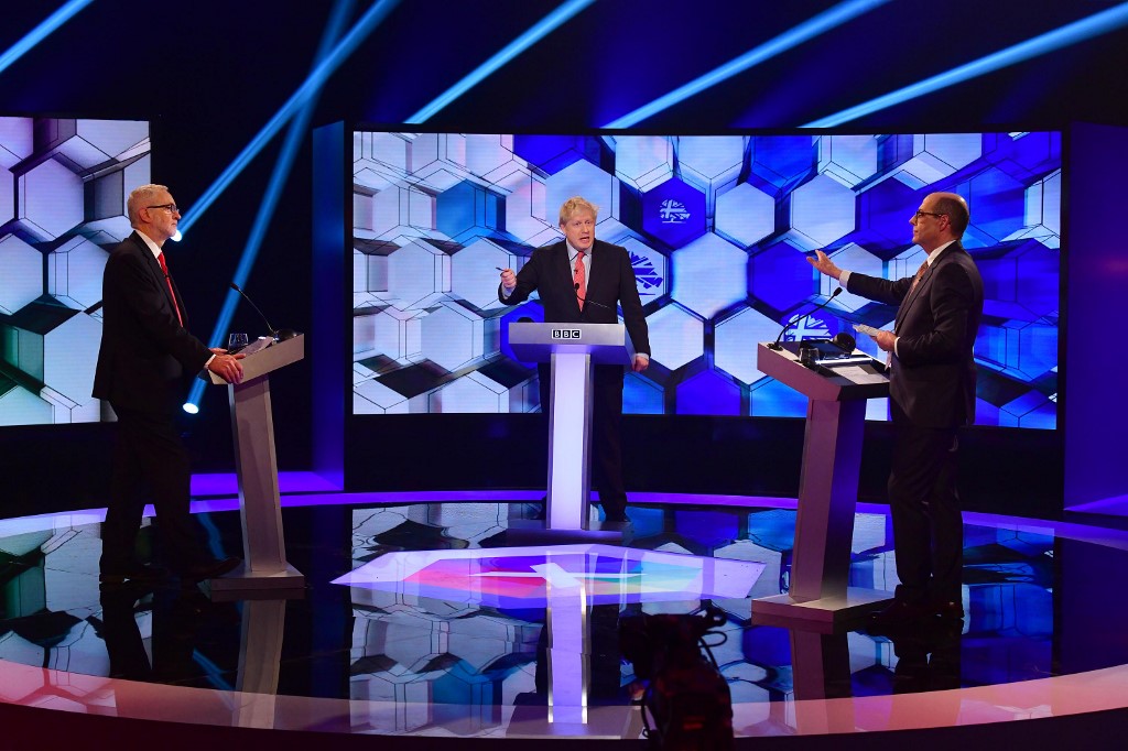 DEBATE. In this handout photograph taken and released by the British Broadcasting Corporation (BBC) on December 6, 2019, Britain's Prime Minister Boris Johnson (C) and Britain's main opposition Labour Party leader Jeremy Corbyn (L) participate in the BBC Prime Ministerial leaders debate. Photo Jeff Overs/BBC/AFP 