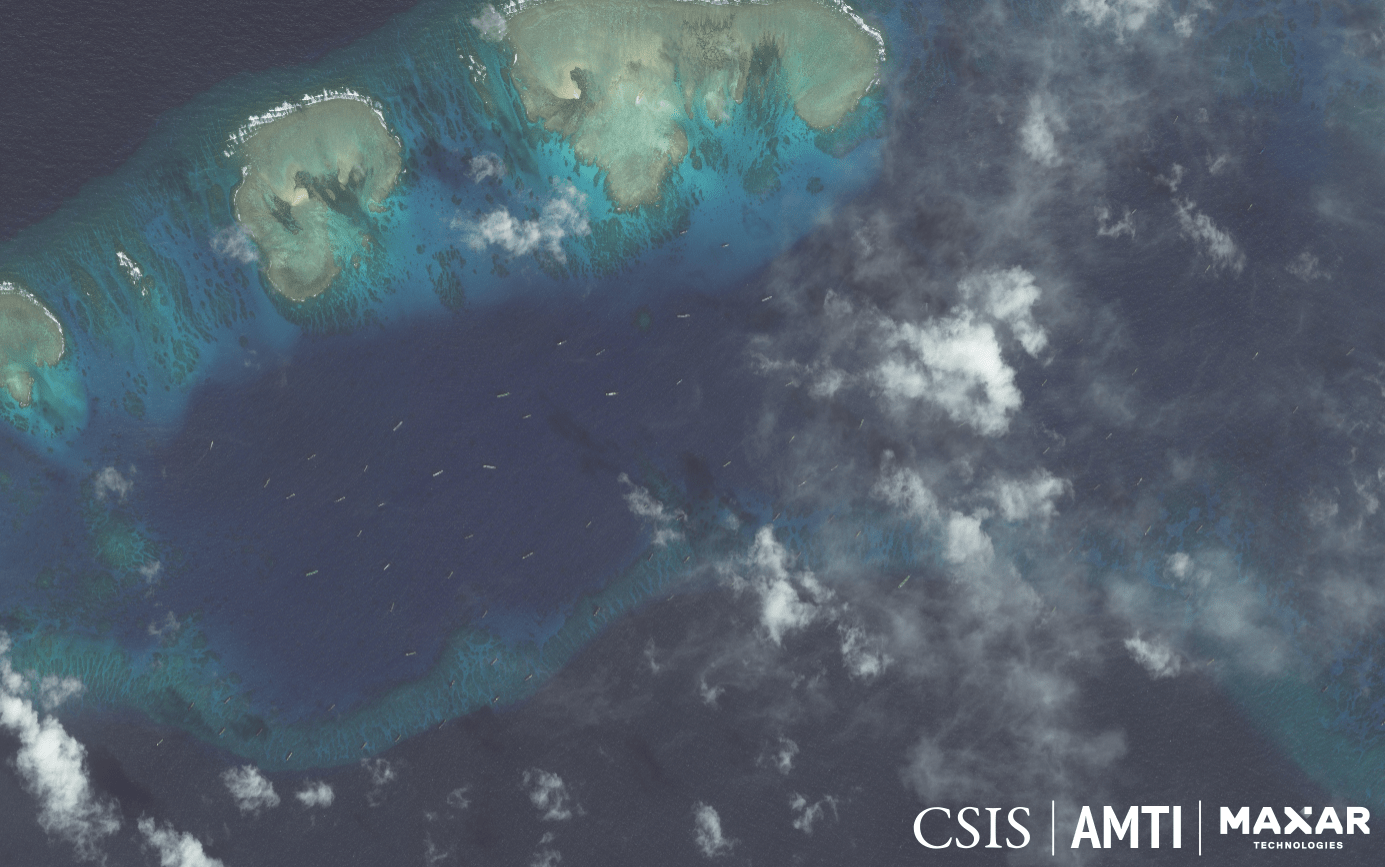 THE SWARM. The tiny specks on the water's surface in this satellite image are Chinese fishing boats whose constant, idle presence among the sandbars just off Pag-asa Island lead analysts to conclude they are militias. Photo from AMTI-CSIS 