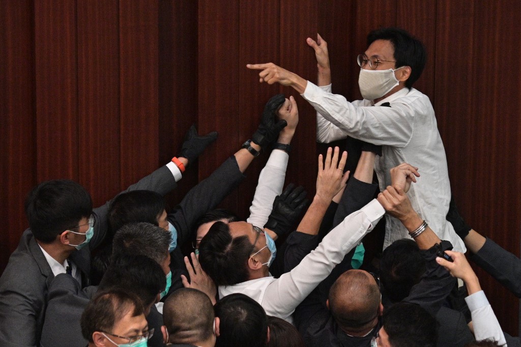 LEGISLATURE TROUBLES. Pro-democracy lawmaker Eddie Chu Hoi-dick (top C) shouts at security trying to restrain him after pro-Beijing lawmaker Starry Lee (not seen) sat in the chairperson's seat before a key committee meeting at the Legislative Council in Hong Kong on May 8, 2020. Photo by Anthony Wallace/AFP 