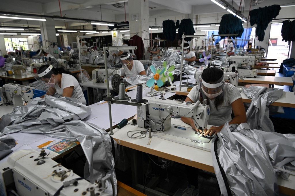 MANUFACTURING. Workers make personal protective equipment for distribution to frontliners, at a factory in Taytay, Rizal, on April 24, 2020. Photo by Ted Aljibe/AFP 