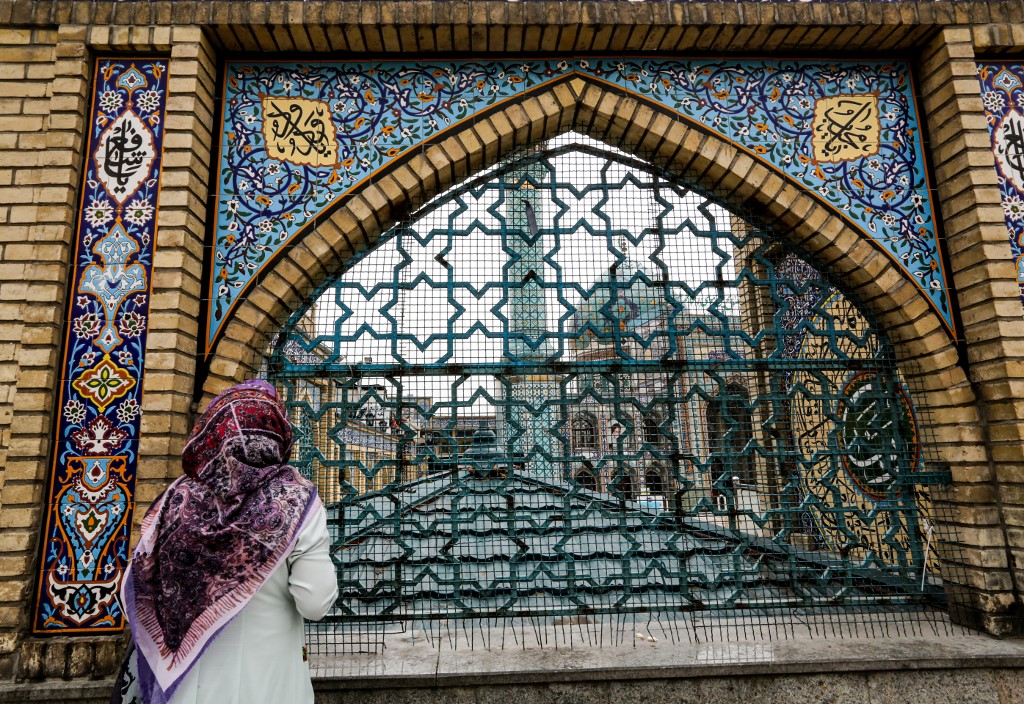 COVID-19 IN IRAN. In this file photo, a woman stands by the fence outside the Imamzadeh Saleh in the Iranian capital Tehran's Shemiran district on April 25, 2020 during the Muslim holy month of Ramadan, as all mosques and places of worship are closed due to the COVID-19 coronavirus pandemic. File photo by Atta Kenare/AFP 