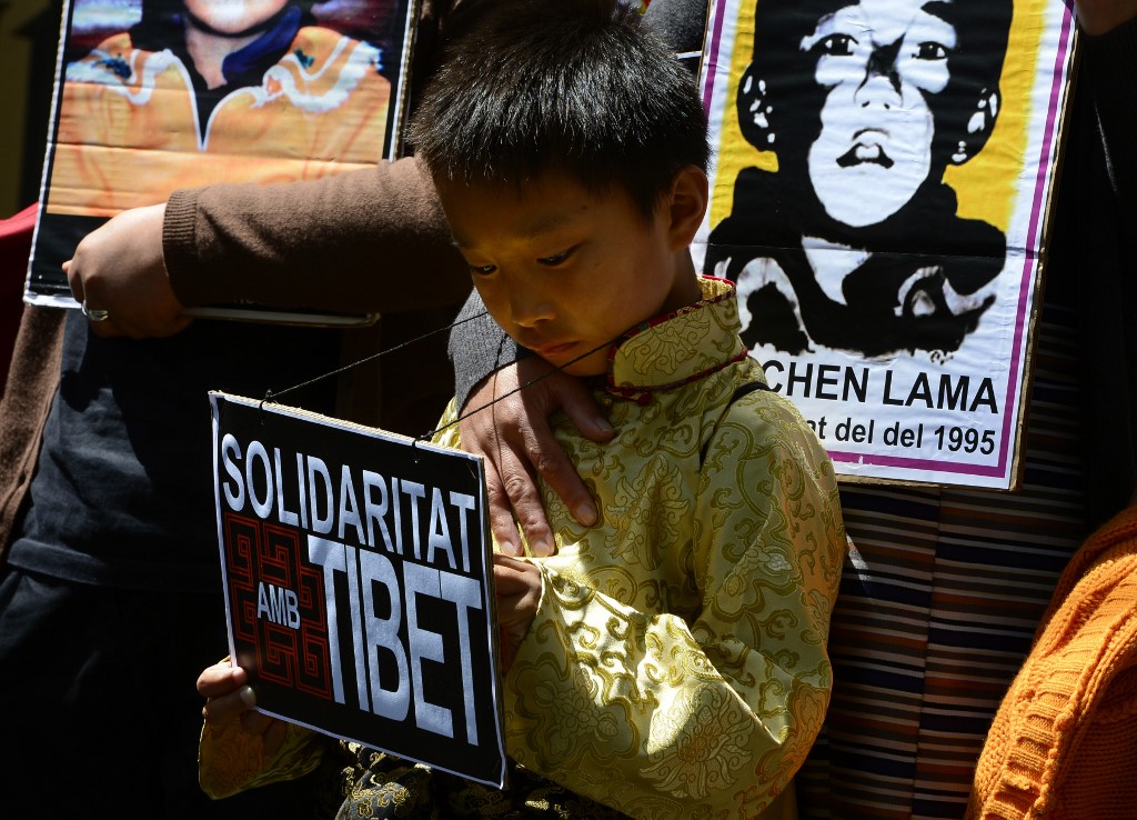 MISSING. In this file photo taken on May 17, 2013 Pro-Tibetan protestors hold picures of Gendun Cheokyi Nyima (the Panchen Lama) during a demonstration outside the Chinese consulate in Barcelona in Barcelona. Photo by Lluis Gene/AFP 