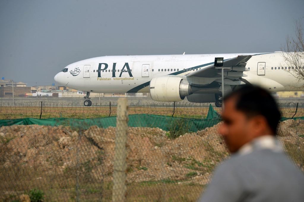 PIA AIRCRAFT. A man looks on as a Pakistan International Airlines plane taxis on the runway at the airport in Islamabad. Photo by Farooq Naeem/AFP 
