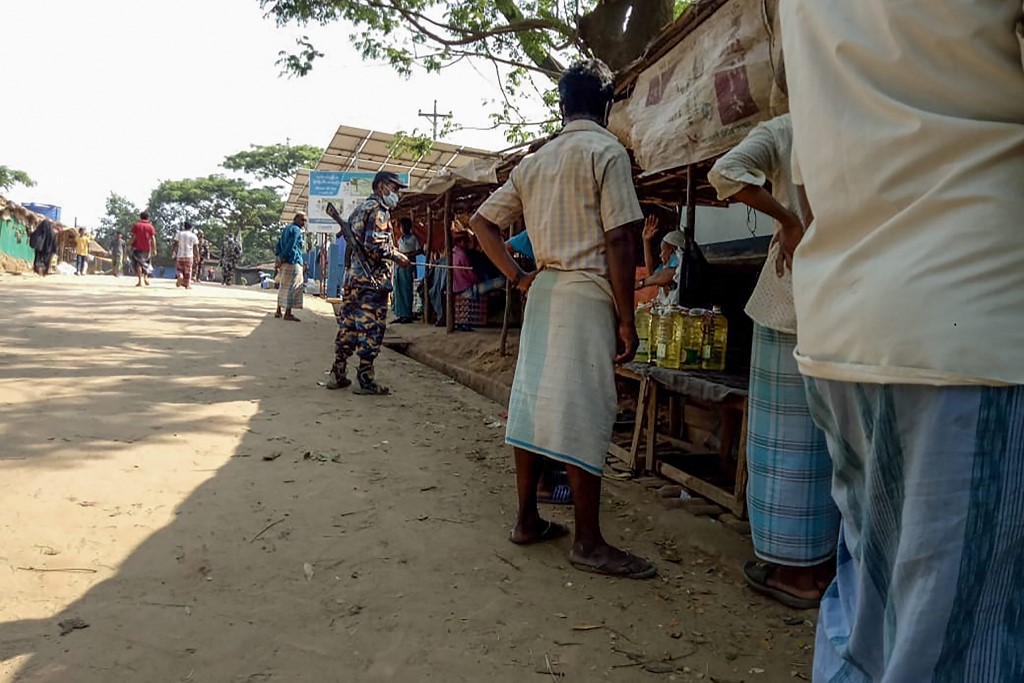 COX'S BAZAR. A security personnel patrols an alley as Rohingya refugees buy groceries from shops during a government-imposed lockdown of Cox's Bazar district as a preventive measure against the coronavirus, in Ukhia on April 9, 2020. Photo by Mohammad Kalam/AFP 