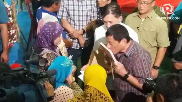 LOVE FOR SOLDIERS. President Rodrigo Duterte kisses the photograph of a slain soldier in Western Mindanao Command as he visits the wake of fallen soldiers. Photo by Richard Falcatan/Rappler   