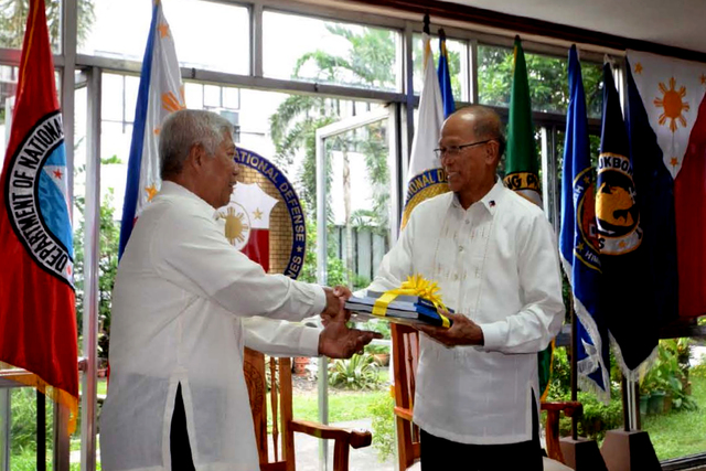 NATIONAL DEFENSE. Outgoing Secretary Voltaire Gazmin hands over his Tour of Duty and Technical Report to incoming DND Secretary Delfin Lorenzana in a transition ceremony in Camp Aguinaldo on June 29. Photo from the DND website.  