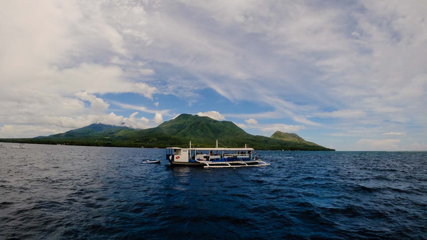 DIVE TME. A dive boat hold anchors above divers location as the majestic volcano Mount Hibok-hibok looms over the distance. Photo by Bobby Lagsa/Rappler 
