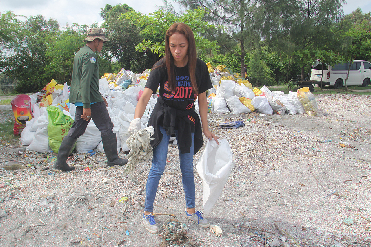PLASTIC PROBLEM. Despite efforts of NGOs and corporations, the Philippines' plastic problem persists. File photo shows a volunteer picking up trash that litters the shoreline of Freedom Island in Paranaque City. Photo by Rhaydz Barcia/Rappler 
