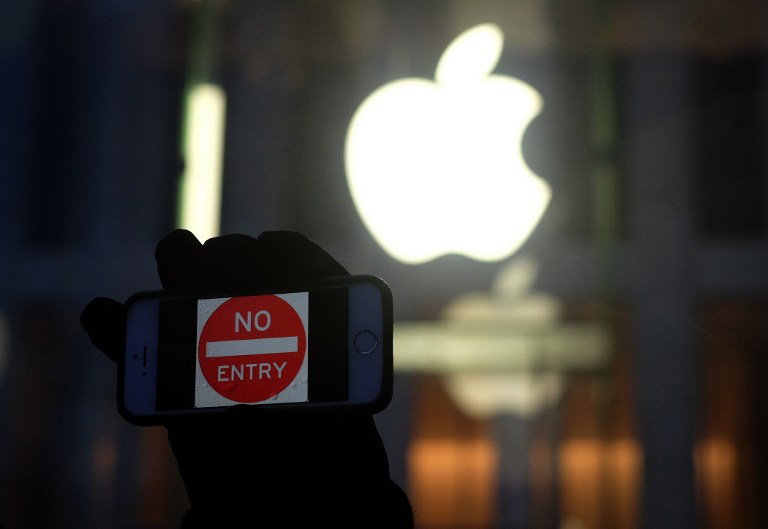 An anti-government protester holds up his iPhone with a sign 'No Entry' during a demonstration near the Apple store on Fifth Avenue in New York on February 23, 2016. Jewel Samad/AFP 
