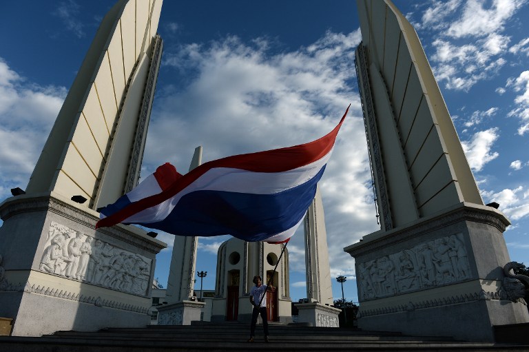 A man waves a giant national flag at Democracy Monument in Bangkok on May 23, 2014. Christophe Archambault/AFP 