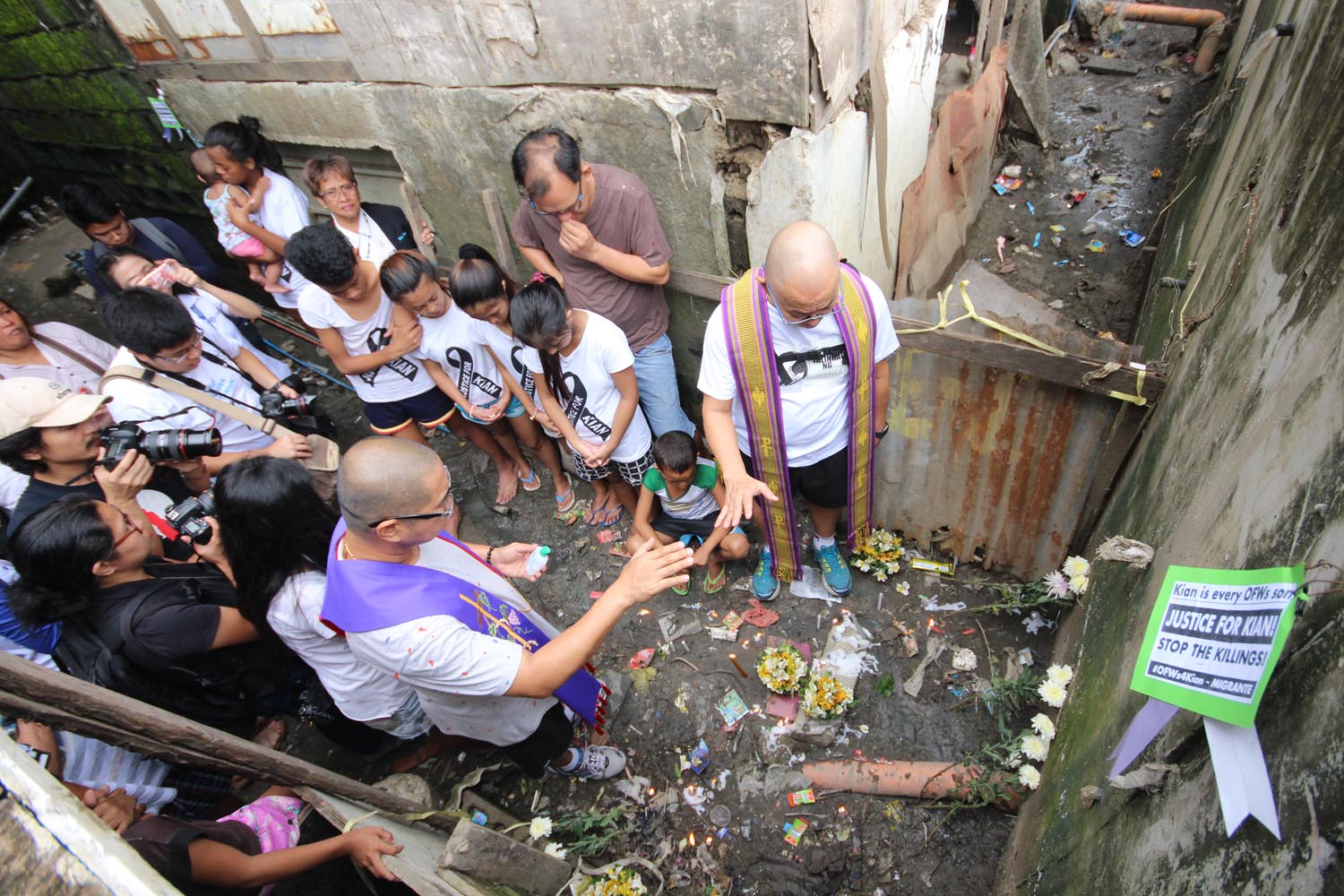 KILLINGS. A priest offers prayers, candles and flowers at the site where 17-year-old student Kian Loyd delos Santos was murdered by Caloocan police. File photo by Darren Langit/Rappler  