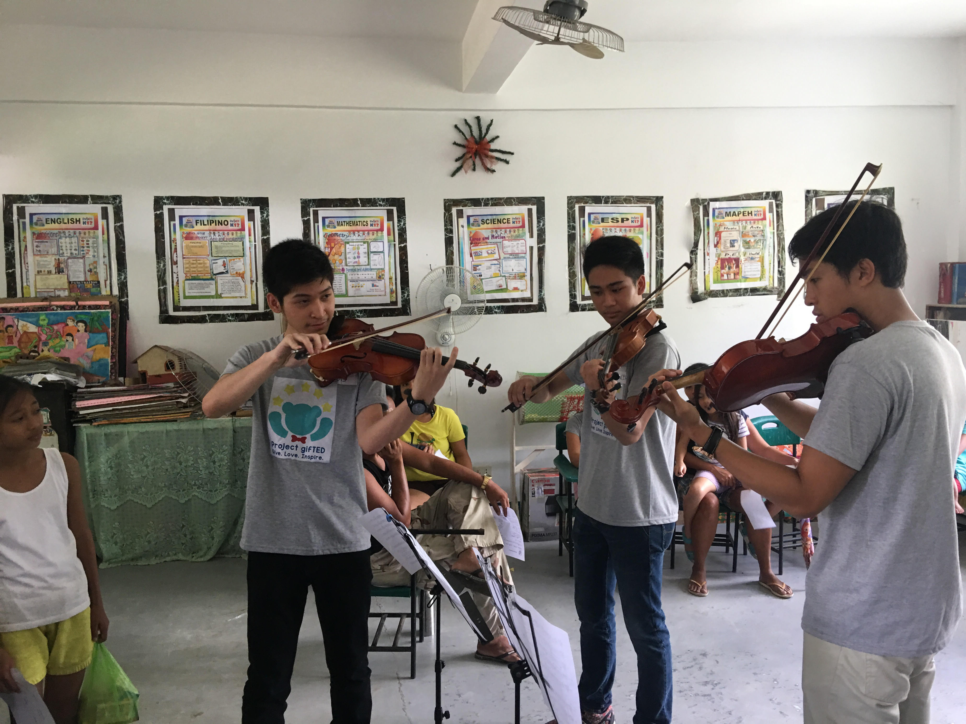 MUSIC THERAPY. Project Gifted members  play the violin for some out-of-school youth in Cavite. Photo by Project Gifted   