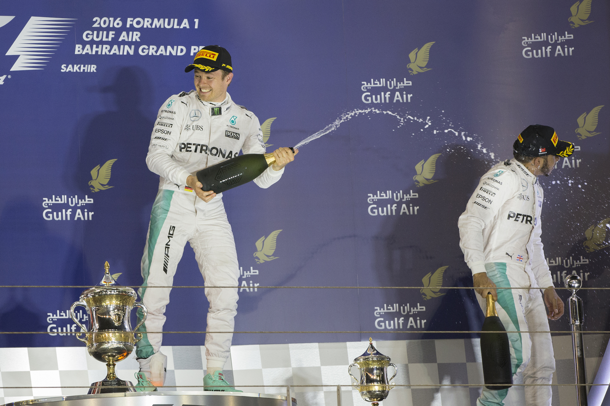 SELEBRASI. Nico Rosberg merayakan kemenangannya di GP Bahrain bersama rekan setimnya yang 'finish' di posisi tiga Lewis Hamilton. Foto oleh Valdrin Xhemaj/EPA 