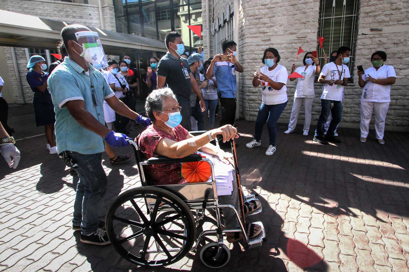 RECOVERY. Health workers greet a patient being wheeled out of the Vicente Sotto Memorial Medical Center (VSMMC) in Cebu City, Philippines on April 24, 2020, after recovering from COVID-19. Photo by Gelo Litonjua/Rappler 