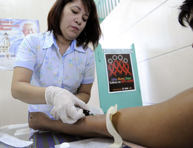 'TIME TO ACT.' A Filipina medical technologist at the social hygiene clinic of Manila Health Department extracts blood for HIV screening test November 28, 2008 from a male client said he had sexual contact with a commercial sex worker. File photo by Romeo Gacad/AFP  