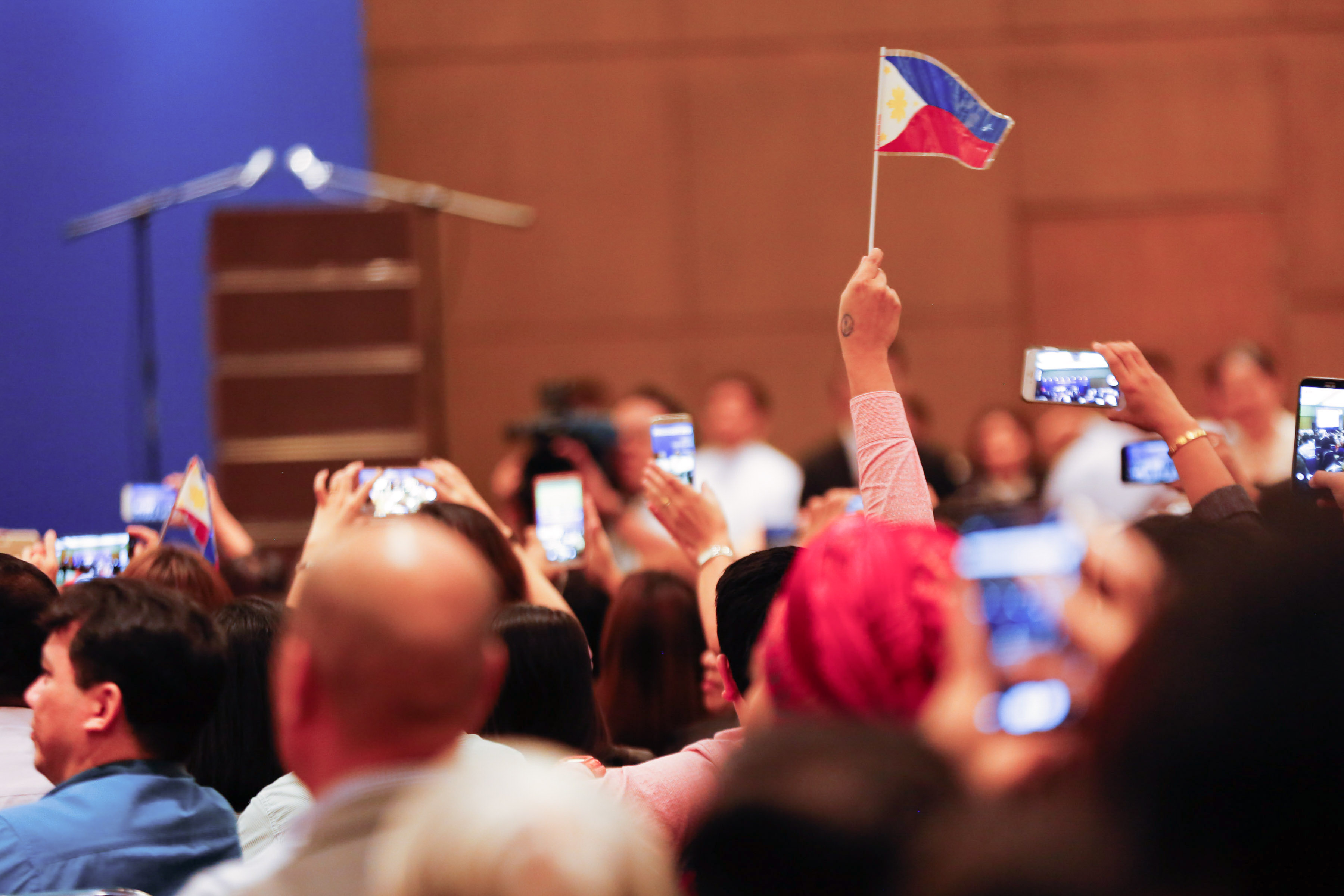 FILIPINO COMMUNITY. A member of the audience waves the Philippine flag in a meeting of the Filipino community in Malaysia with President Rodrigo Duterte in November 2016. Photo by Toto Lozano/Malacañang photo.  