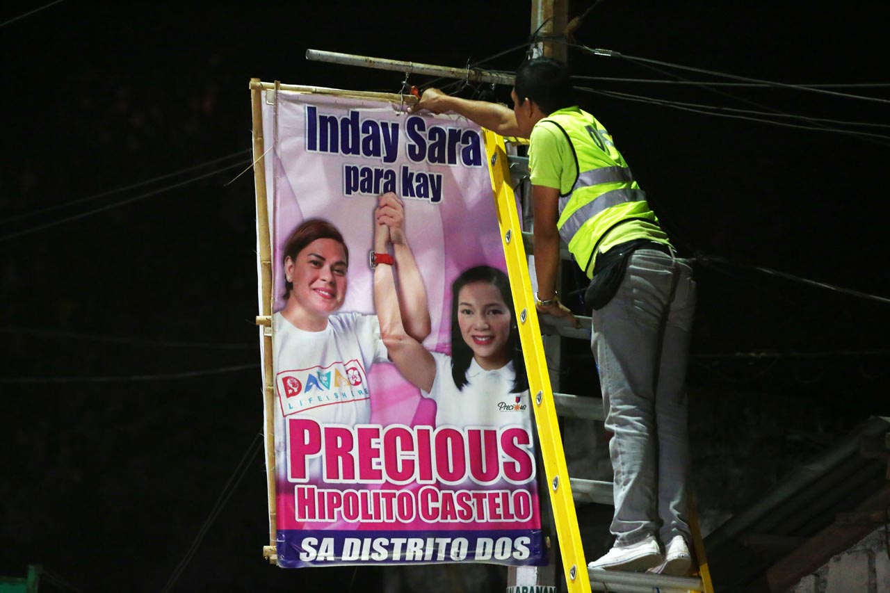 HAZARD. Posters that pose as hazards to commuters and residents are dismantled. Photo by Ben Nabong/Rappler  