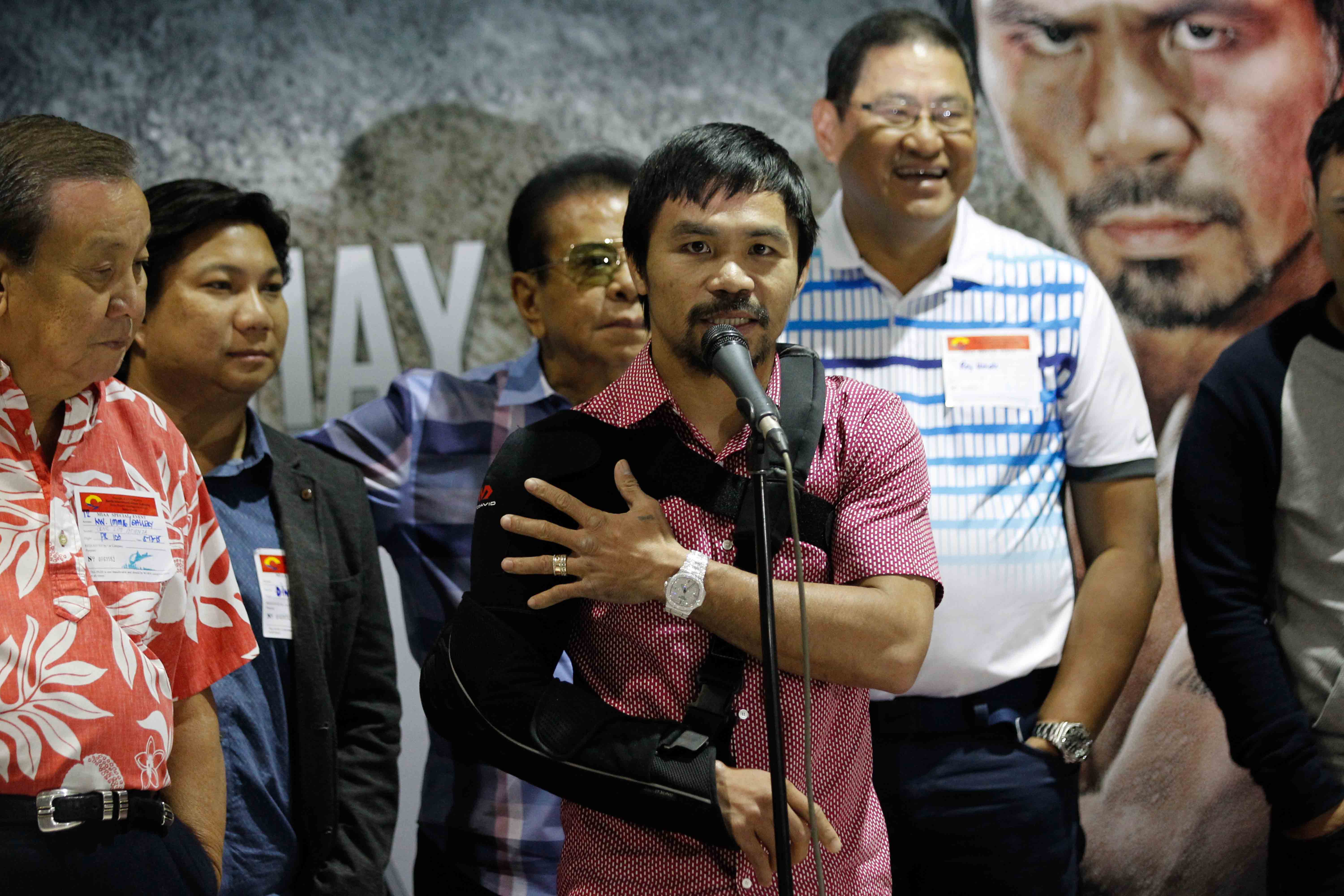 WHO LOST? Filipino boxer Manny Pacquiao, in an arm sling, addresses fans upon his arrival in Manila, Philippines, on May 13, 2015. Photo by Czeasar Dancel  