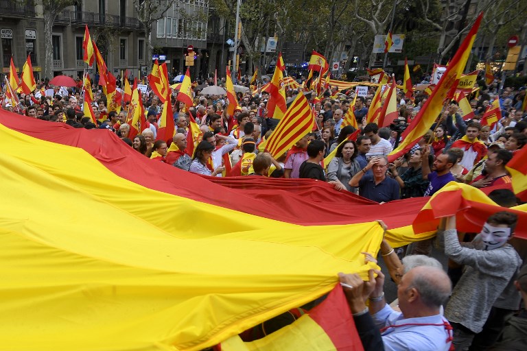 SCENARIOS. People hold a giant Spanish flag during a demonstration against independence in Catalonia, on September 30, 2017 in Barcelona. Photo by Lluis Gene/AFP 