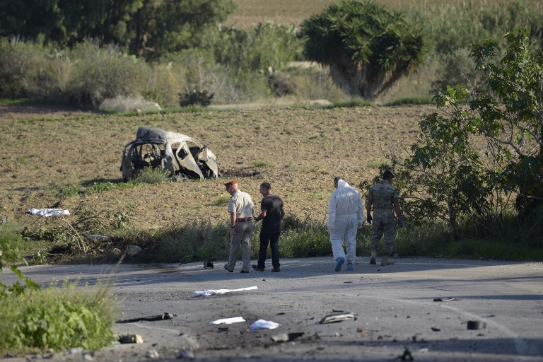 CRIME SCENE. Police and forensic experts inspect the wreckage of a car bomb believed to have killed journalist and blogger Daphne Caruana Galizia close to her home in Bidnija, Malta, on October 16, 2017.  Stringer/AFP 
