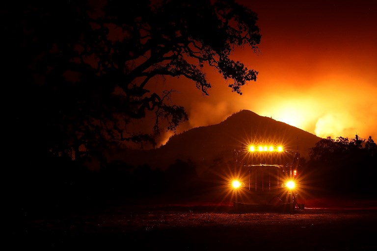 WILDFIRES. A fuel truck sits in a staging area as the Nuns Fire burns in the hills behind it on October 10, 2017 in Kenwood, California. Photo by Justin Sullivan/Getty Images/AFP 