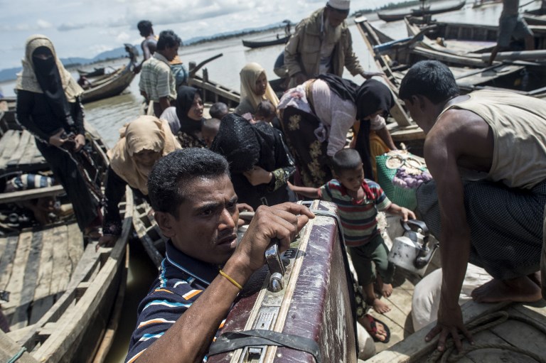 REFUGEES. Rohingya Muslim refugees disembark from a boat to go in a camp for refugees after they crossed the border from Myanmar, in Teknaf on October 3, 2017. Photo by Fred Dufour/AFP 