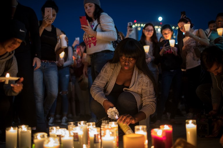 IN MOURNING. Mourners light candles during a vigil at the corner of Sahara Avenue and Las Vegas Boulevard for the victims of Sunday night's mass shooting, October 2, 2017 in Las Vegas, Nevada. Drew Angerer/Getty Images/AFP 