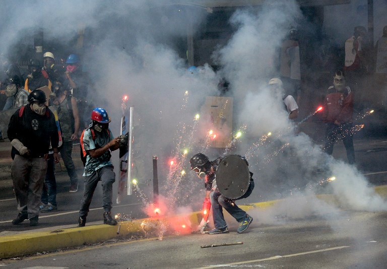 UNREST IN CARACAS. Demonstrators clash with riot police during a protest against the government of President Nicolas Maduro in Caracas on May 20, 2017. Federico Parra/AFP 