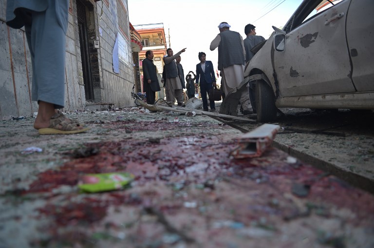 DEADLY ATTACK. Afghan residents inspect the site of a suicide bombing outside a voter registration center in Kabul on April 22, 2018. Photo by Shah Marai/AFP 