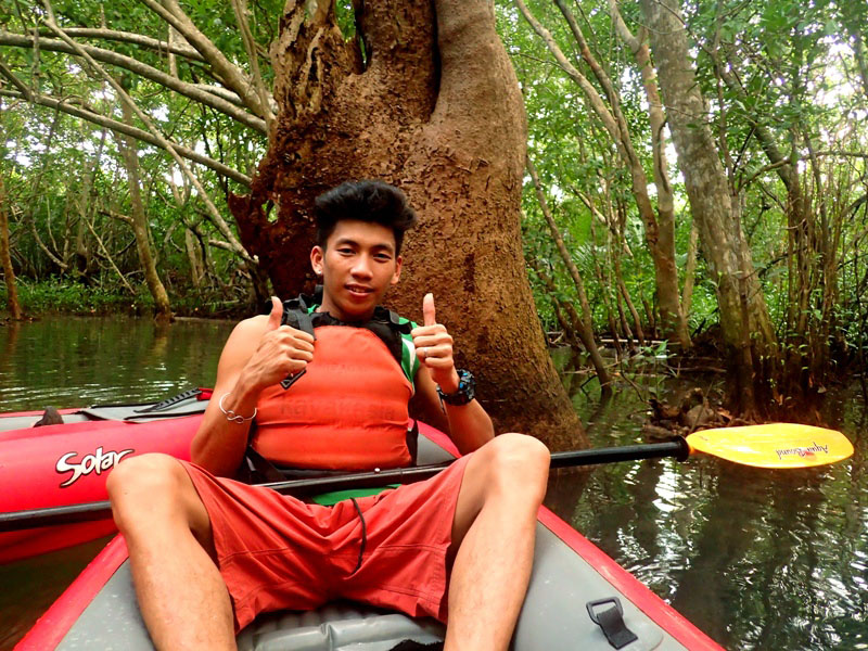 RIVER PROTECTOR. Jeremy Morquiala, 27, is a kayak guide and is also a member of Abatan River’s local organization working to protect the river and its mangroves. Behind him is one of the river’s century-old mangroves. 