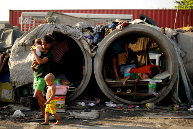 POVERTY. Families live in concrete pipes used as makeshift dwellings along a street in Manila on March 22, 2016. File photo by Noel Celis/AFP 