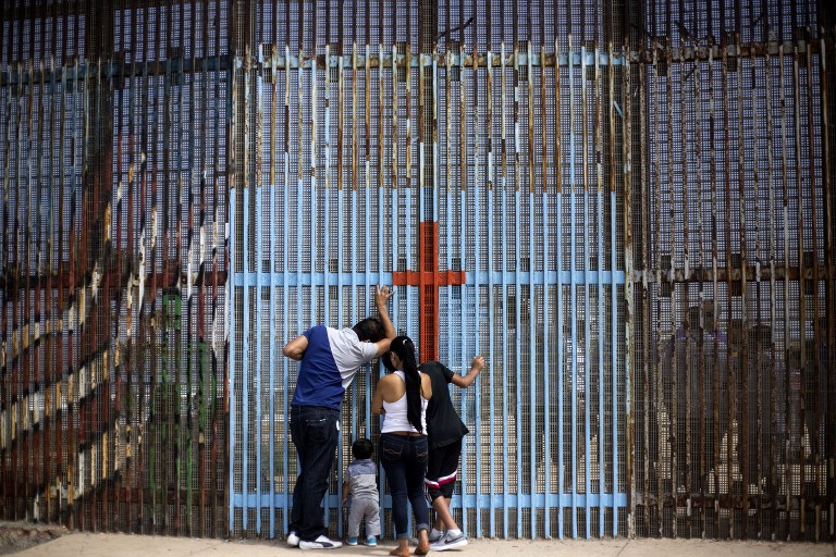 SEPARATED. A family talks with with relatives through the US - Mexico border fence in Playas de Tijuana, in Tijuana, northwestern Mexico, on July 2, 2016. Guillermo Arias/AFP 
