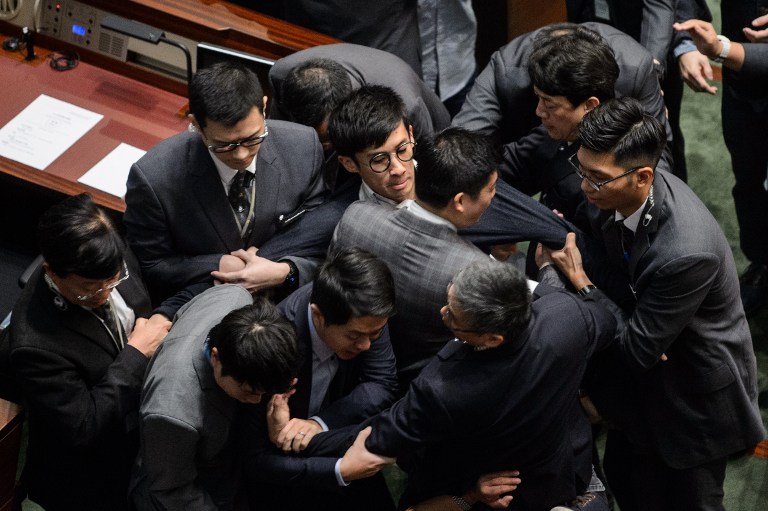 Newly elected lawmaker Baggio Leung (C, wearing glasses) is restrained by security after attempting to read out his Legislative Council oath at Legco in Hong Kong on November 2, 2016. Anthony Wallace/AFP 
