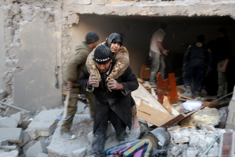 A Syrian rescuer carries a woman who was rescued from the rubble of a building following reported airstrikes on Aleppo's rebel-held district of al-Hamra on November 20, 2016. Thaer Mohammed/AFP 