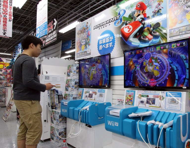 WII U. A customer plays a video game of Nintendo's Wii U at an electric shop in Tokyo on May 7, 2015. File photo by Yoshikazu Tsuno/AFP   