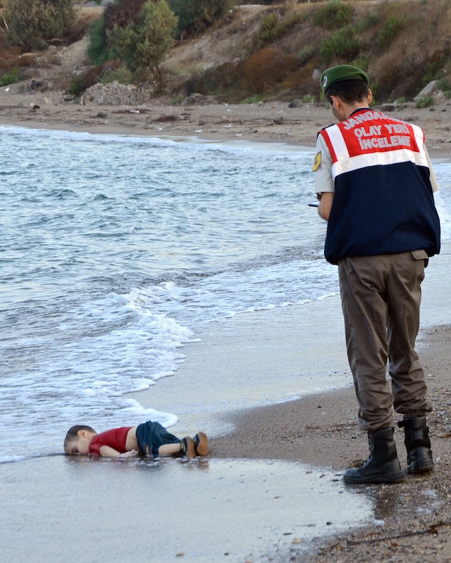 VICTIM. Turkish police stand near by the washed up body of a refugee child who drowned during a failed attempt to sail to the Greek island of Kos, at the shore in the coastal town of Bodrum, Mugla city, Turkey, September 2, 2015. Dogan News Agency/EPA 
