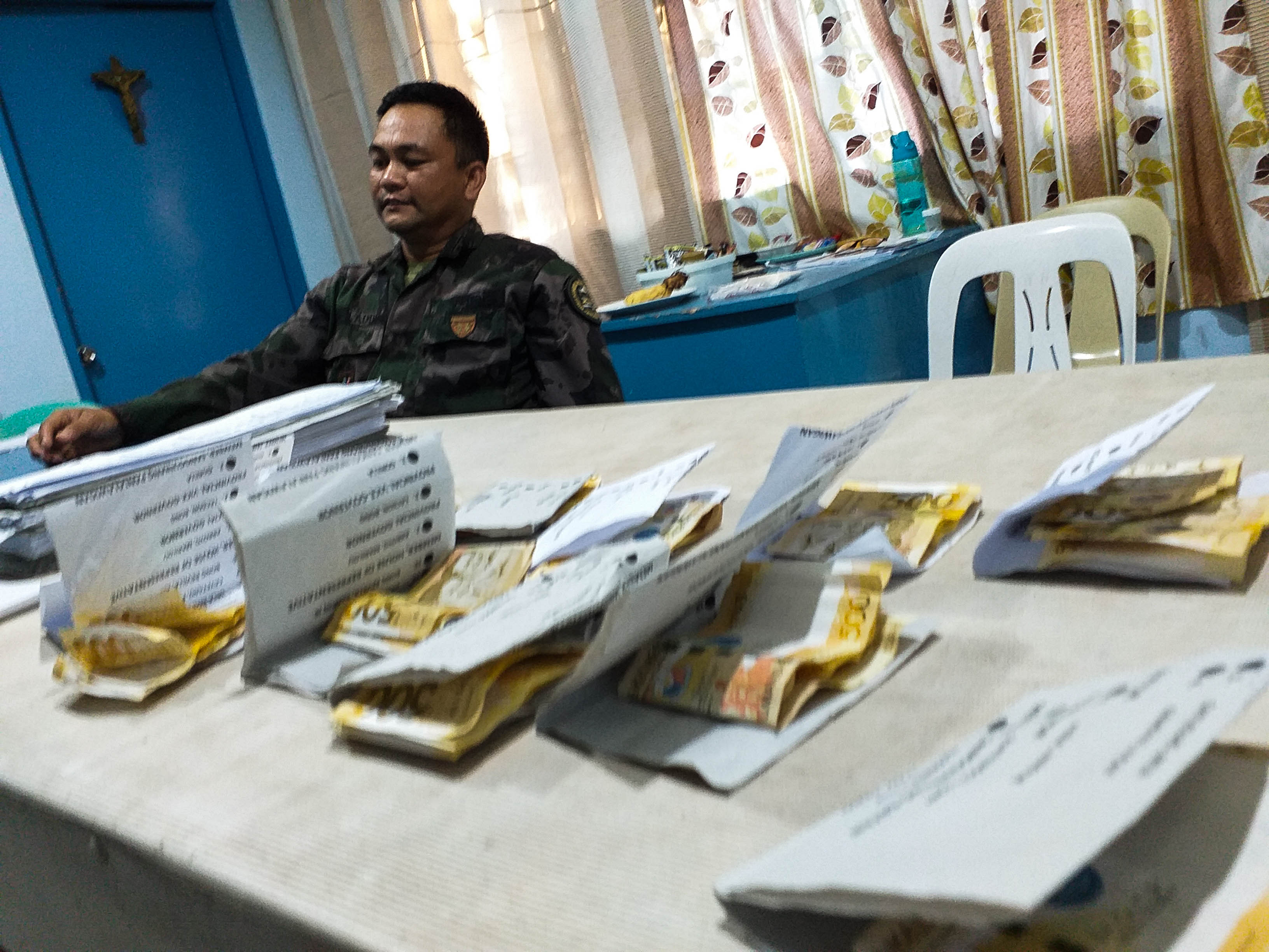VOTE-BUYING. Authorities show to media sample ballots enclosed with P1,000 cash seized from suspects in Moises Padilla towno on May 12, 2019. Photo by Marchel Espina/Rappler 