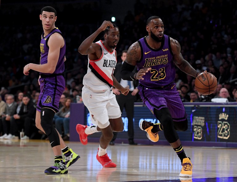 ON A ROLL. LeBron James drives around a screen set by Los Angeles teammate Lonzo Ball as he's chased by Portland's Al-Farouq Aminu in the game won by the streaking Lakers. Photo by Harry How/Getty Images/AFP  