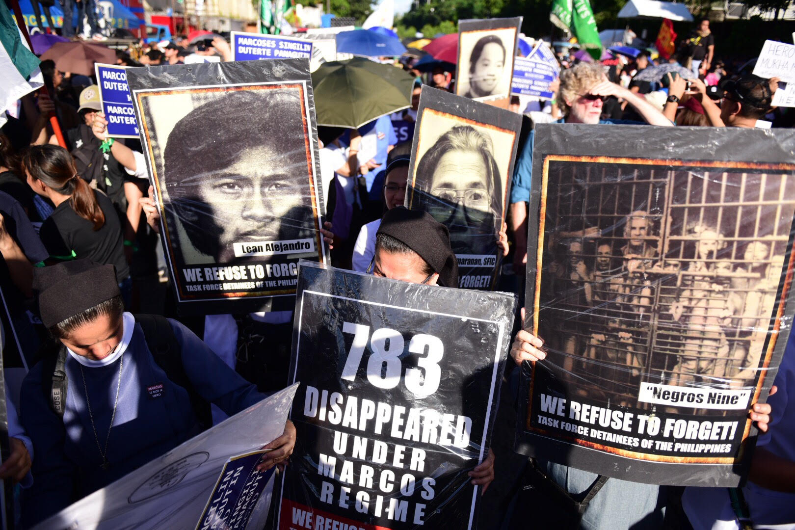 SACRIFICE. Anti-Marcos protesters held photos of victims of human rights abuses under Martial Law during the grand rally at the People Power monument on November 30.  