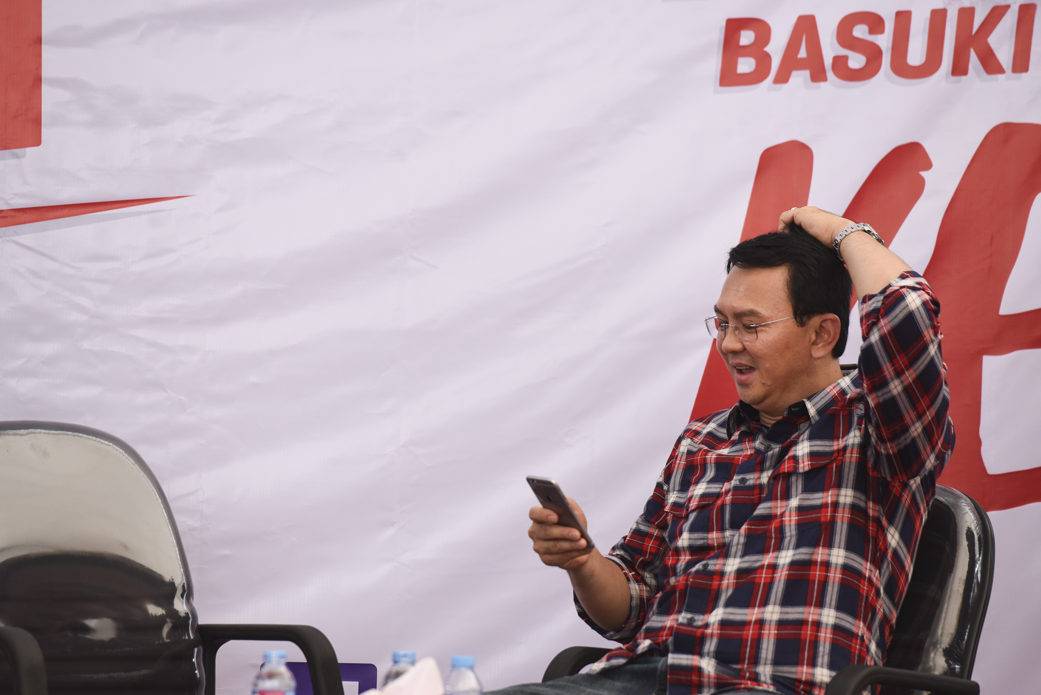 Gubernur DKI Jakarta petahana Ahok memainkan telepon selularnya saat menerima pengaduan warga di Rumah Lembang, Jakarta, pada 16 November 2016. Foto oleh Hafidz Mubarak A/Antara 