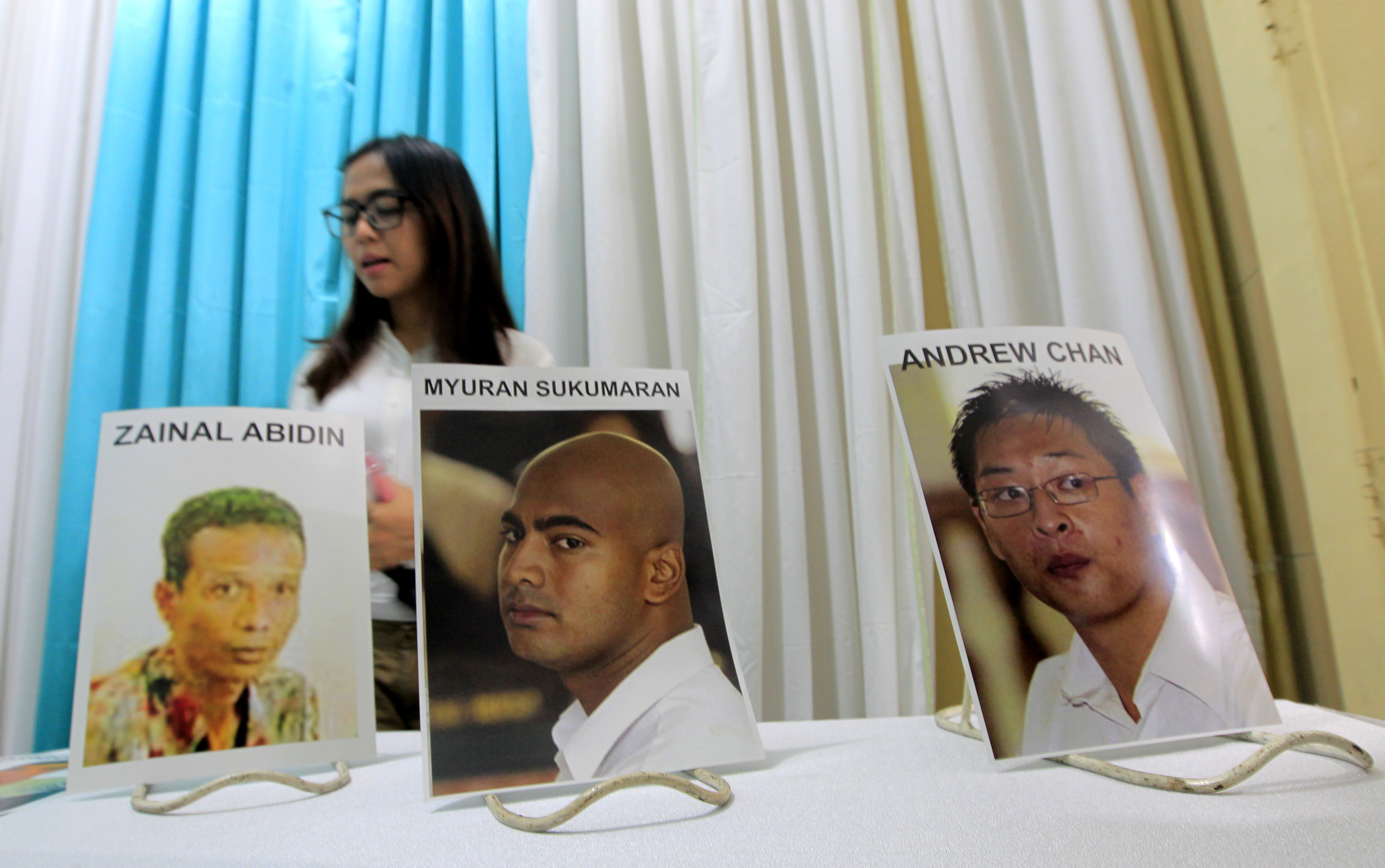 An Indonesian girl walks past pictures of executed Australian death-row prisoners Andrew Chan (R) and Myuran Sukumaran (C), and Indonesian Zainal Abidin, on display at Saint Carolus funeral home in Jakarta, Indonesia, 29 April 2015. Photo by Bagus Indahono/EPA 