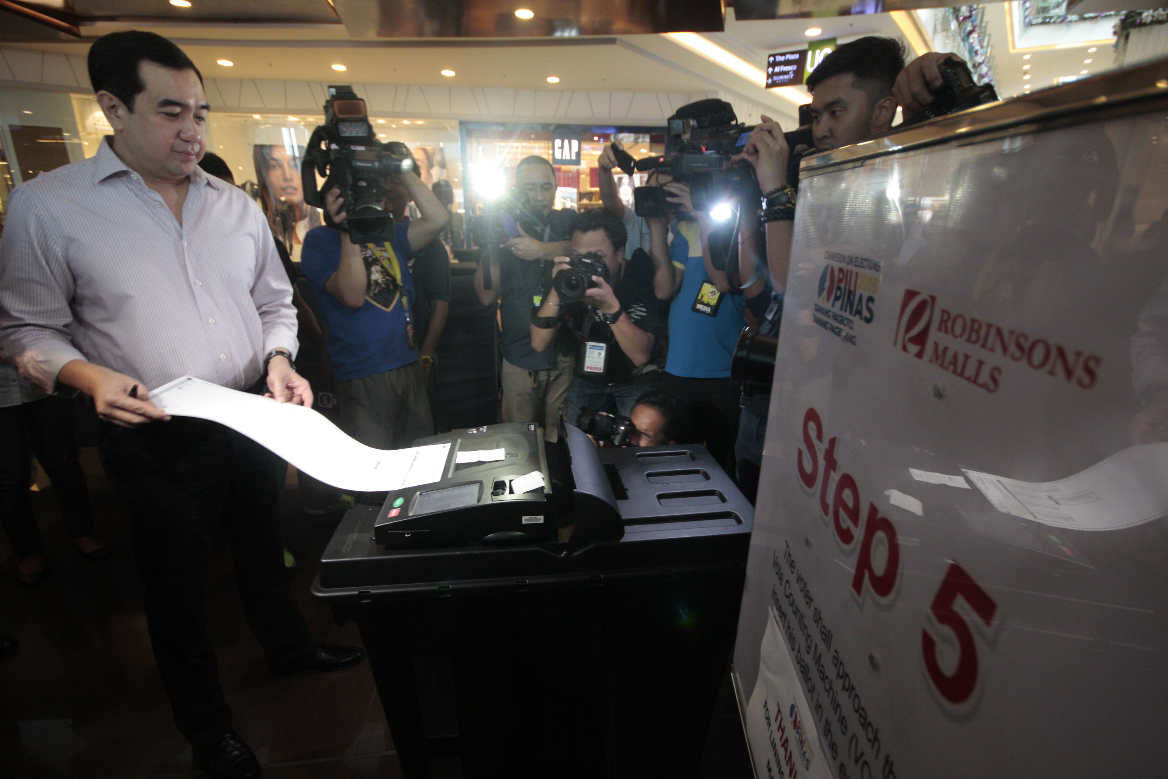 TESTING THE PROCESS. Comelec Chairman Andres Bautista uses a vote-counting machine as he demonstrates the voting procedure in a Metro Manila mall in October 2015. Photo by Ben Nabong/Rappler  