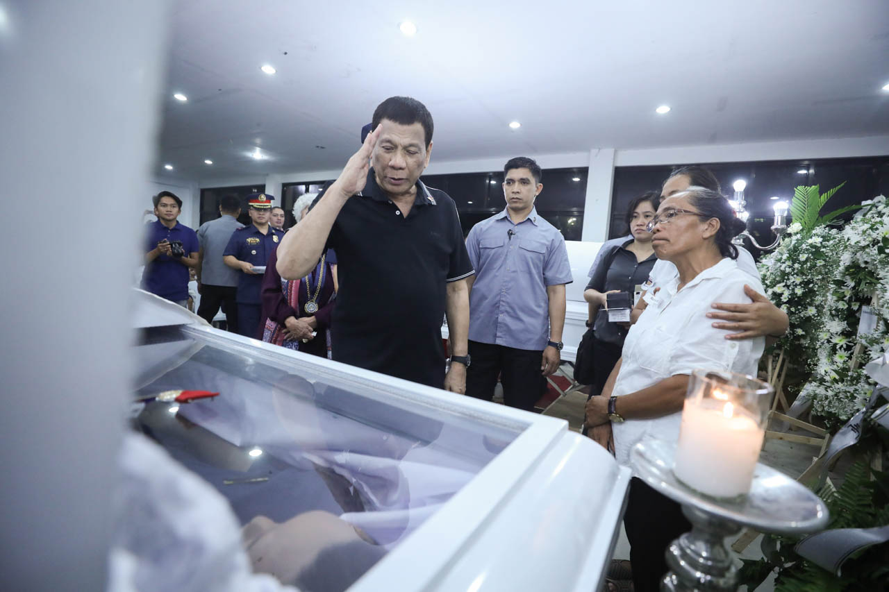 RETRIBUTION. President Rodrigo Duterte pays his last respects to one of the police officers killed in Negros Oriental. Malacañang photo 