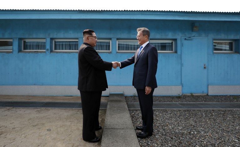 TWO KOREAS. North Korea's leader Kim Jong-Un (L) shakes hands with South Korea's President Moon Jae-in (R) at the Military Demarcation Line that divides their countries ahead of their summit at the truce village of Panmunjeom on April 27, 2018. AFP PHOTO / Korea Summit Press Pool 
