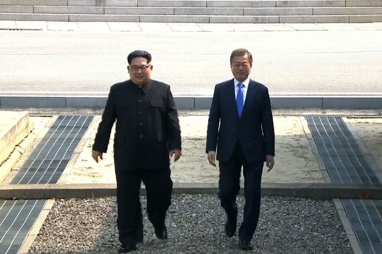 INTER-KOREAN SUMMIT. This screengrab from the Korean Broadcasting System (KBS) taken on April 27, 2018 shows North Korea's leader Kim Jong-Un (L) and South Korea's President Moon Jae-in walking together past the Military Demarcation Line that divides their countries at Panmunjeom. AFP PHOTO / KOREAN BROADCASTING SYSTEM (KBS) 