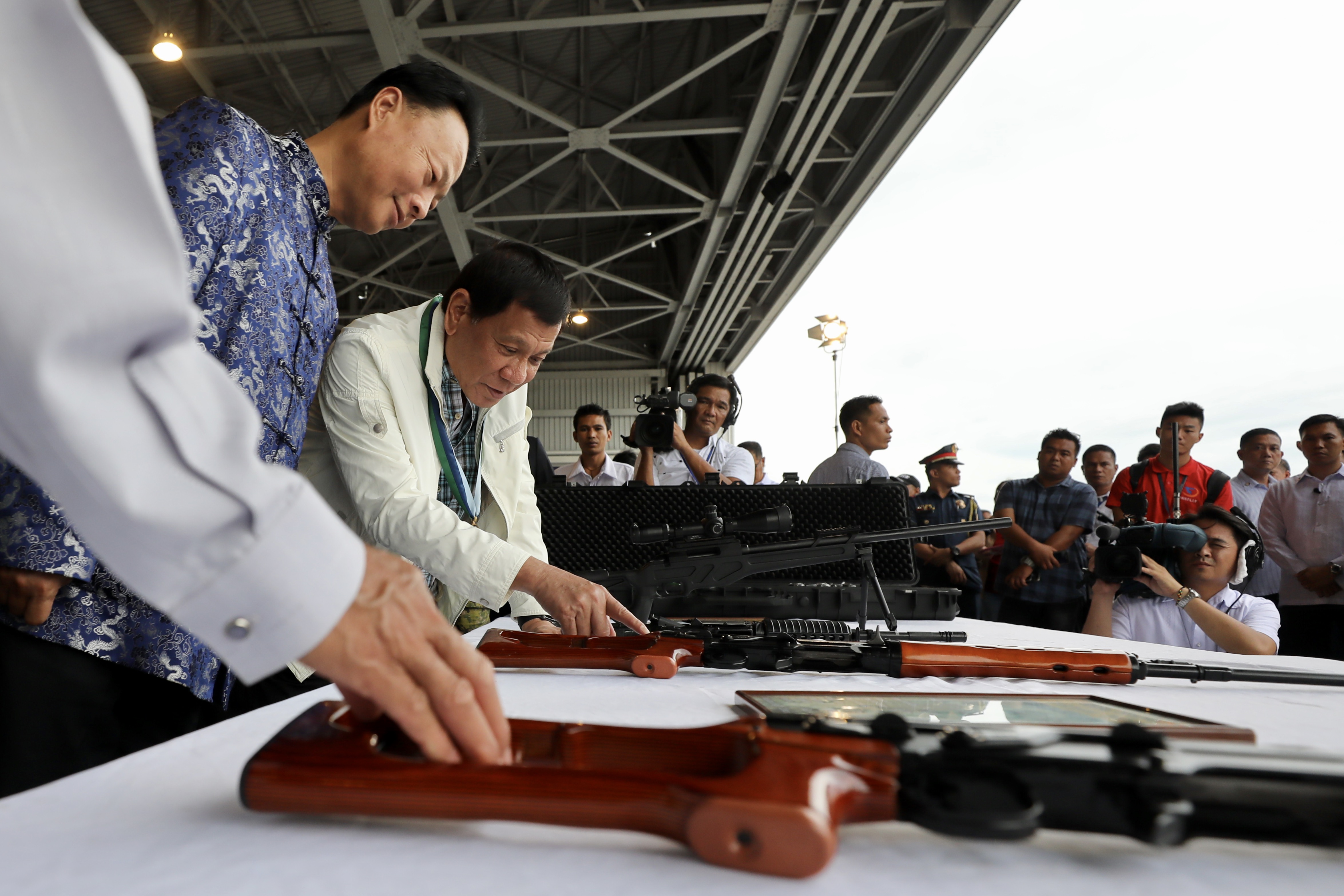 WARM TIES. President Rodrigo Duterte examines firearms donated by China in the presence of Chinese Ambassador Zhao Jianhua. Malacañang file photo  